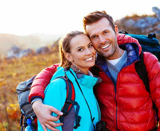 Young couple in mountains smiling
